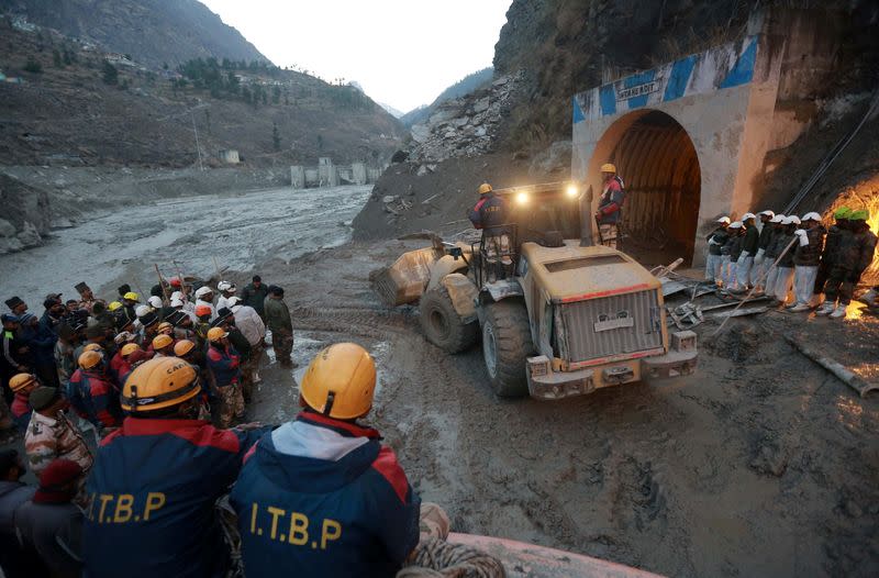 Members of Indo-Tibetan Border Police watch as a machine is used to clear a tunnel after a part of a glacier broke away, in Tapovan