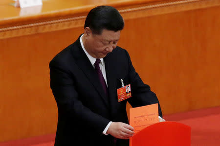 Chinese President Xi Jinping drops his ballot during a vote at the fifth plenary session of the National People's Congress (NPC) at the Great Hall of the People in Beijing, China March 17, 2018. REUTERS/Jason Lee