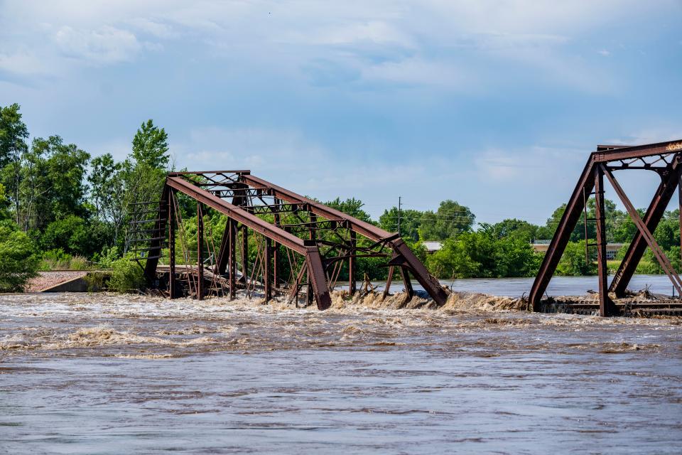 Floodwaters on the Big Sioux River flow over a collapsed BNSF railroad bridge between North Sioux City, South Dakota, and Sioux City, Monday, June 24, 2024.