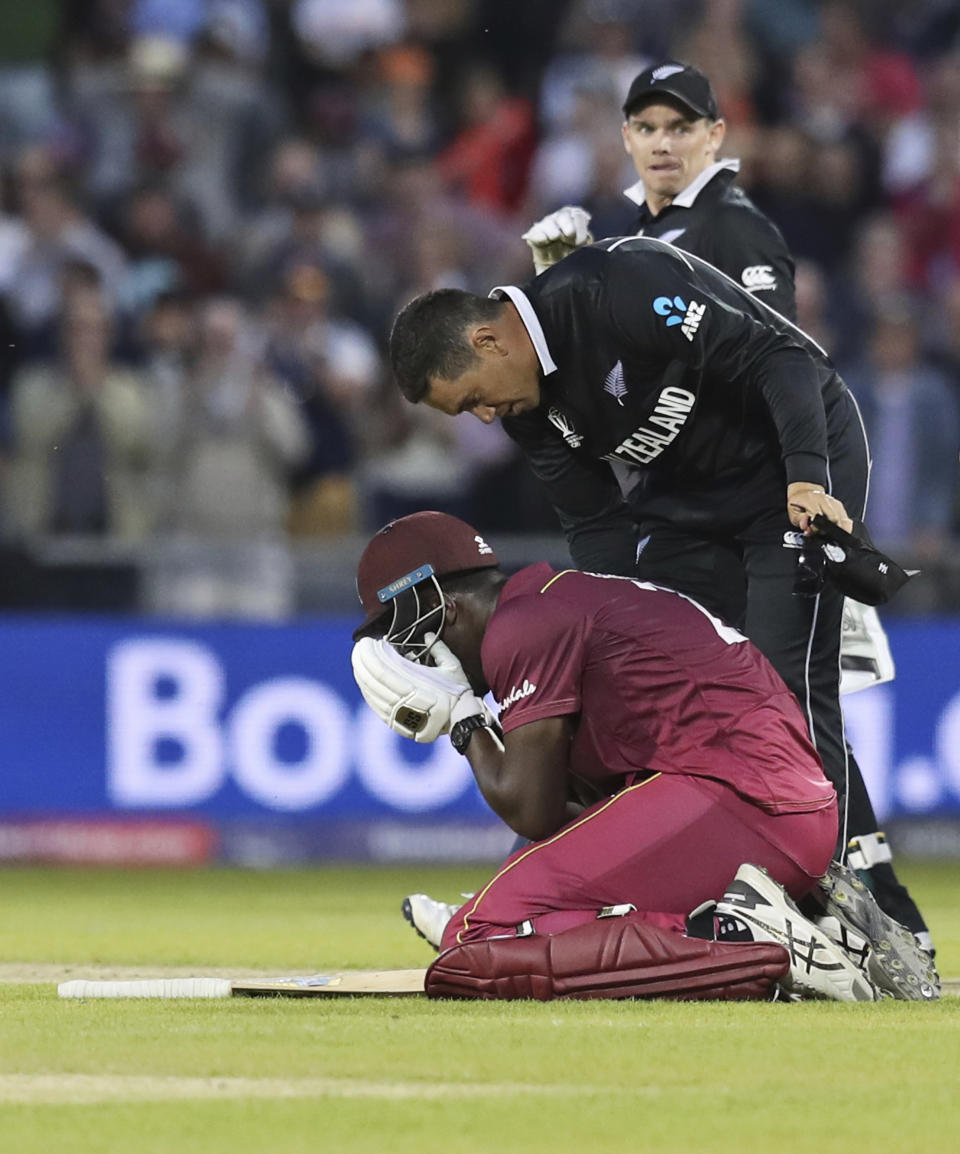 New Zealand's Ross Taylor consoles West Indies' Carlos Brathwaite at the end of the Cricket World Cup match between New Zealand and West Indies at Old Trafford in Manchester, England, Saturday, June 22, 2019. (AP Photo/Jon Super)