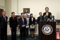 Ti-anna Wang (R), daughter of political prisoner Wang Bingzhang, speaks with U.S. Representative Chris Smith (R-NJ) (2nd R) behind her during a news conference on Capitol Hill in Washington in this January 18, 2011 file photo. REUTERS/Hyungwon Kang/Files