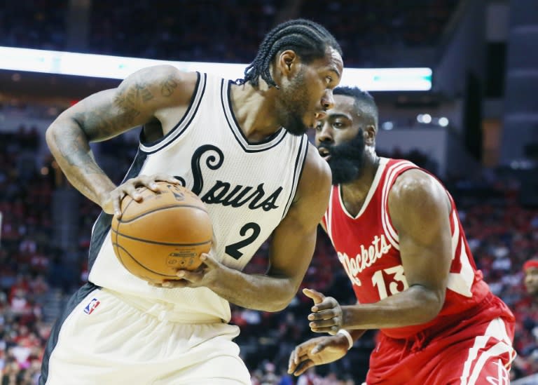 Kawhi Leonard (L) of the San Antonio Spurs scored 16 of his game-high 23 points in the first half as the Spurs humiliated the Dallas Mavericks 116-90 on the Mavs' home floor