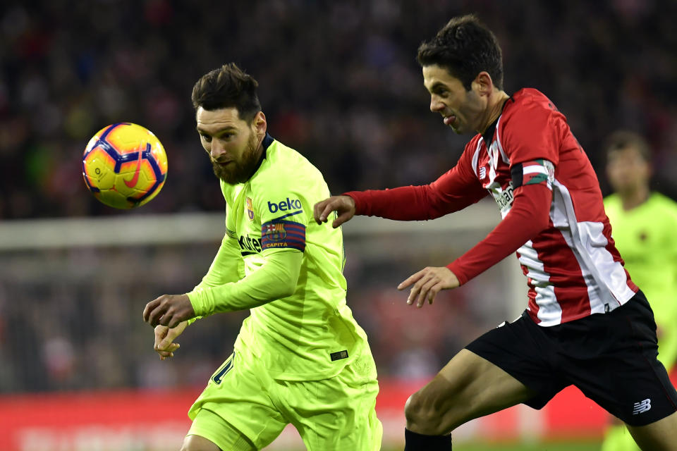 FC Barcelona's Lionel Messi, left, duels for the ball beside Athletic Bilbao's Markel Susaeta during the Spanish La Liga soccer match between Athletic Bilbao and FC Barcelona at San Mames stadium, in Bilbao, northern Spain, Sunday, Feb. 10, 2019.(AP Photo/Alvaro Barrientos)