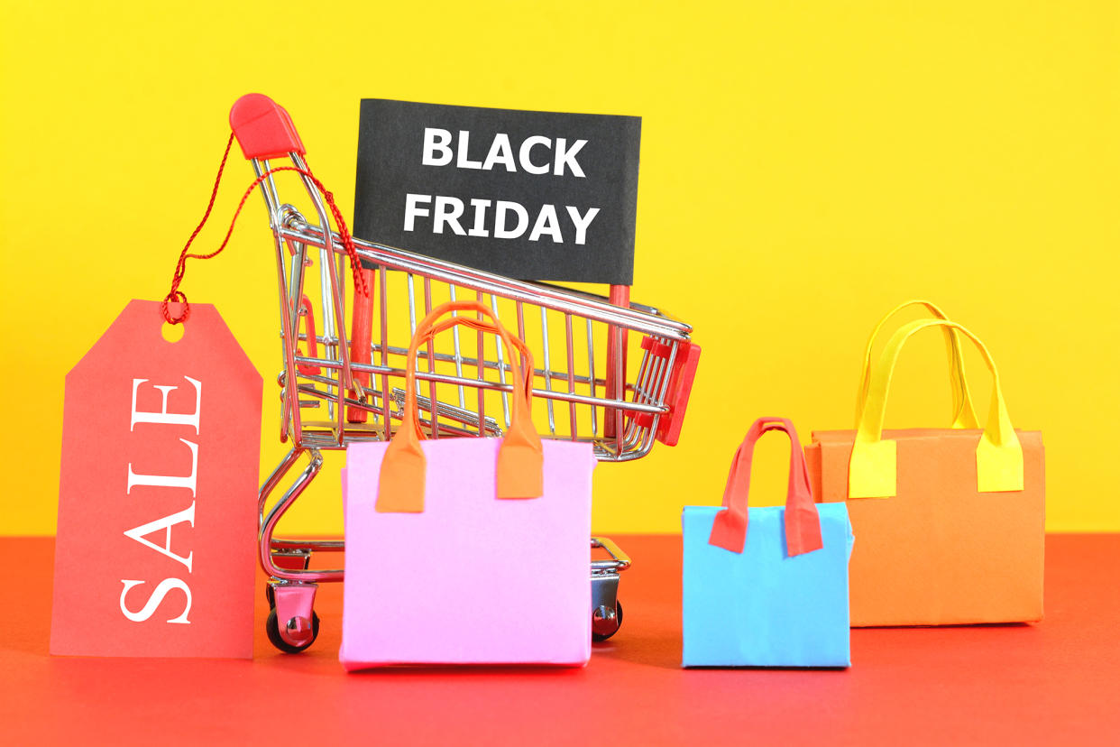 Black Friday Sale concept. Black Friday Sale text on black banner on a shopping cart with colorful shopping bags.