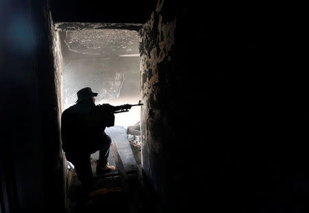 A fighter of Libyan forces allied with the U.N.-backed government aims his weapon as he takes up position inside a ruined house at the front line of fighting with Islamic State militants in Ghiza Bahriya district in Sirte, Libya November 9, 2016. REUTERS/Ismail Zitouny