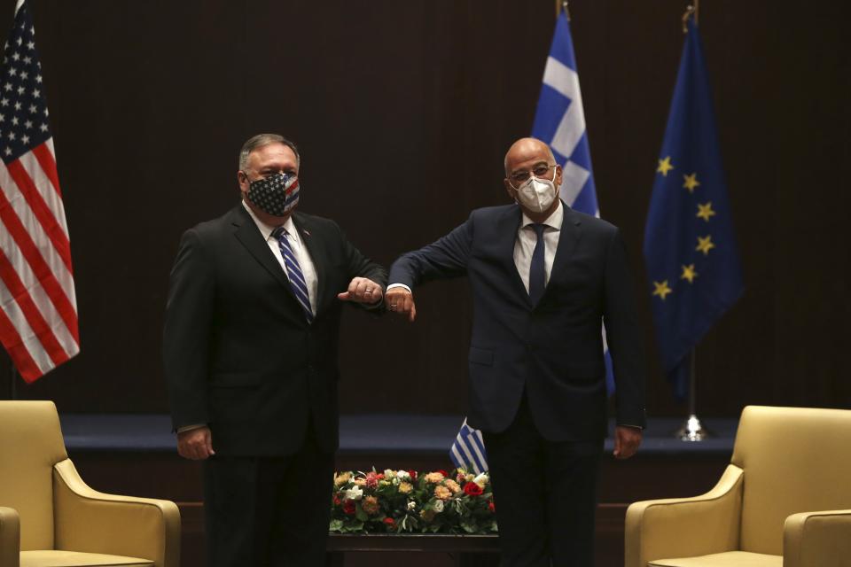 U.S. Secretary of State Mike Pompeo, left, and Greek Foreign Minister Nikos Dendias touch elbows during their meeting in the northern city of Thessaloniki, Greece, Monday, Sept. 28, 2020. Pompeo and Dendias, will sign a bilateral science and technology agreement, as well as host energy sector business leaders for a discussion to highlight energy diversification and infrastructure projects in Greece. (AP Photo/Giannis Papanikos, Pool)
