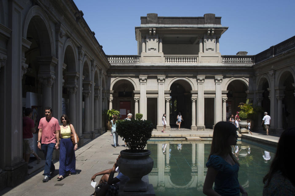 This Sept. 8, 2012 photo shows people visiting an early 20th century mansion at Parque Lage in Rio de Janeiro, Brazil. About a half-mile away from the also-gorgeous but not free Jardim Botanico, or Botanical Gardens, Parque Lage has as much charm as its better-known neighbor. (AP Photo/Felipe Dana)