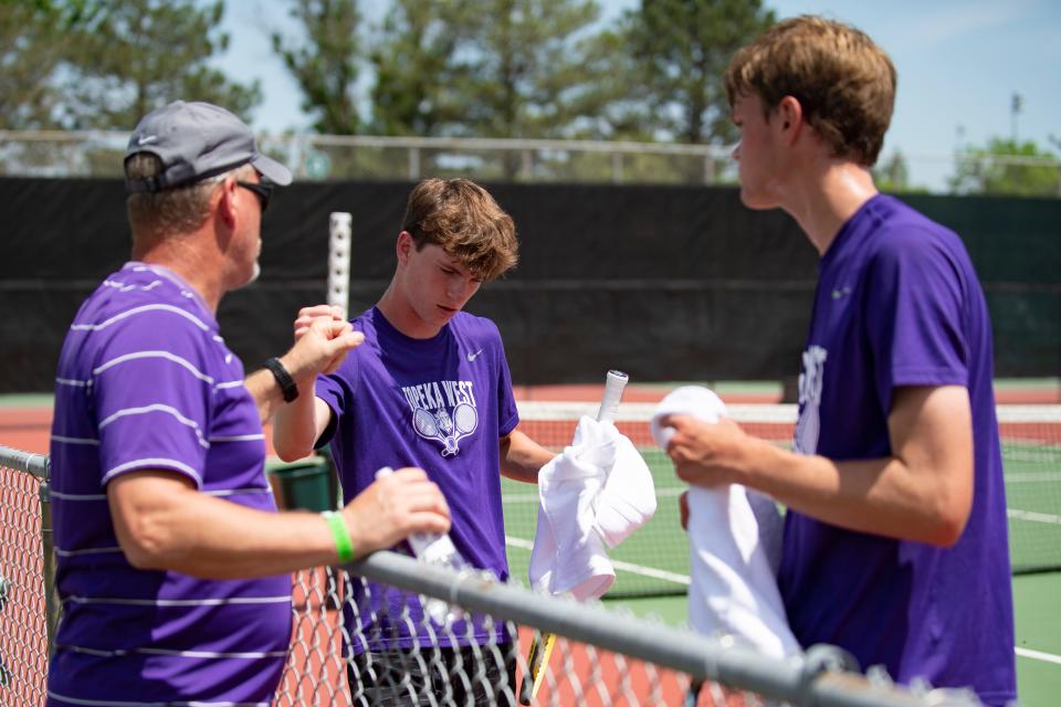 Topeka West Ian Cusick and Miles Cusick speak to head coach Kurt Davids Saturday at Kossover Tennis Court.