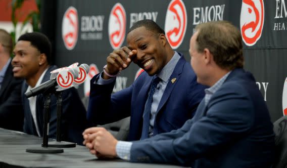 Dwight Howard, center, smiles during a news conference introducing him as the newest member of the Atlanta Hawks NBA basketball team Wednesday July 13, 2016, in Atlanta. Hawks head coach Mike Budenholzer is at right. (Brandt Sanderlin/Atlanta Journal-Constitution via AP)