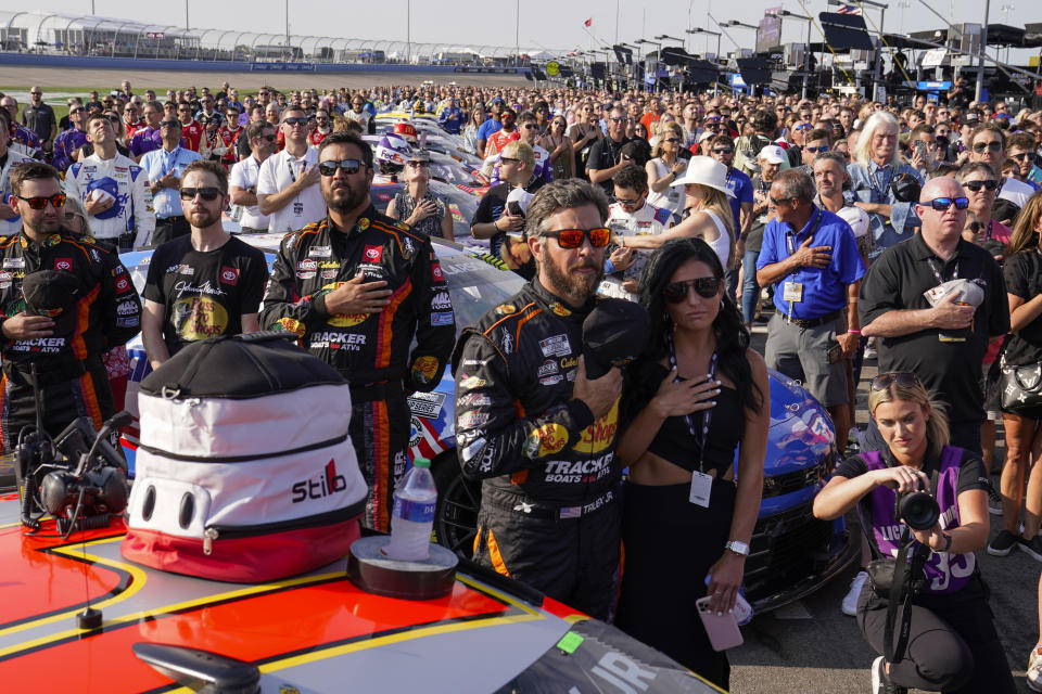Drivers and pit crews stand for the national anthem along pit row before a NASCAR Cup Series auto race Sunday, June 25, 2023, in Lebanon, Tenn. (AP Photo/George Walker IV)