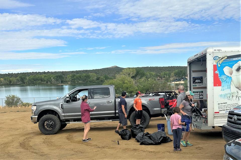 Volunteers load a truck with trash after holding a cleanup day at Lake Farmington. The city has received a state grant to fund other cleanup events at sites around the city in Fiscal Year 2024.