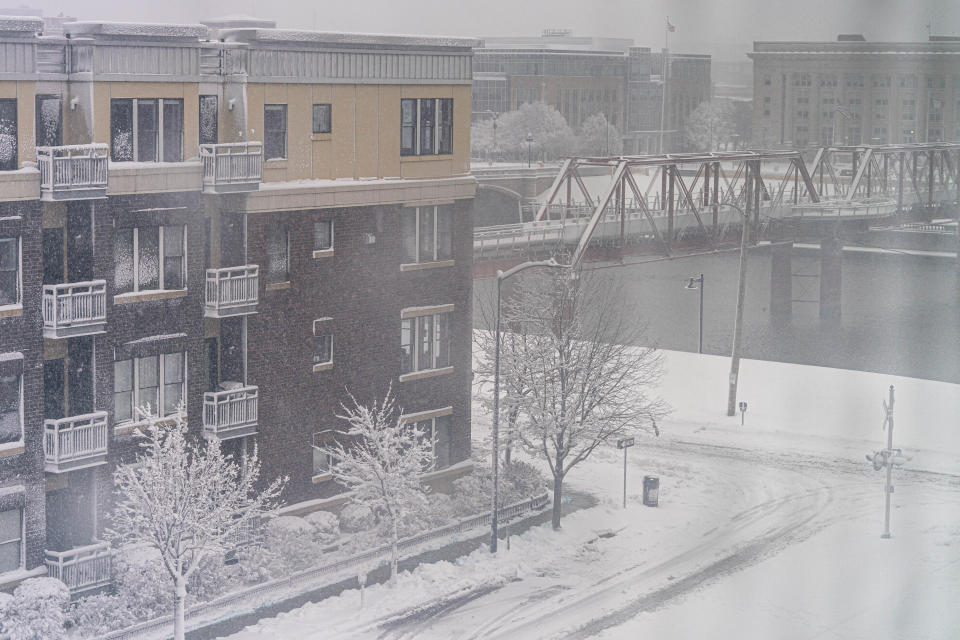 The Des Moines river is visible as snow falls in downtown Des Moines, Iowa, Tuesday, Jan. 9, 2024. (AP Photo/Andrew Harnik)