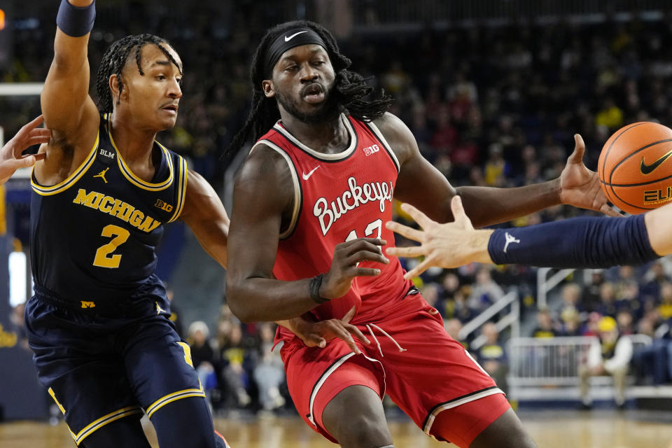 Ohio State guard Isaac Likekele (13) loses control of the ball next to Michigan guard Kobe Bufkin (2) during the first half of an NCAA college basketball game, Sunday, Feb. 5, 2023, in Ann Arbor, Mich. (AP Photo/Carlos Osorio)