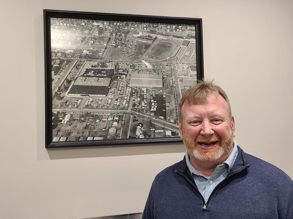 Chambersburg Area School District Superintendent Chris Bigger, pictured in front of photo showing what the neighborhood where the current Administration Building and Chambersburg Area Senior High School are located looked like decades ago.