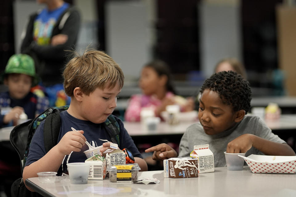 First graders Ripley Phillips, left, and Jabari Hall talk during breakfast at Williams Science and Arts Magnet school Friday, May 10, 2024, in Topeka, Kan. The school is just a block from the former Monroe school which was at the center of the Brown v. Board of Education Supreme Court ruling ending segregation in public schools 70 years ago. (AP Photo/Charlie Riedel)