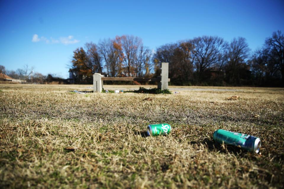 Drink cans can be seen on the ground near a broken bench on Friday, Dec. 15, 2023 at 673 Vance Avenue, the now abandoned lot where Vance Middle School used to be, in Memphis, Tenn.