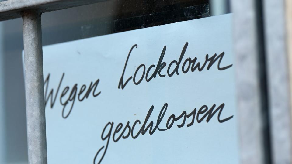 Ein Zettel mit der Aufschrift «Wegen Corona geschlossen» hängt am Schaufenster eines Geschäfts.