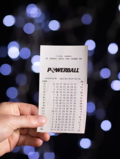 Pictured is a person holding a Powerball ticket.