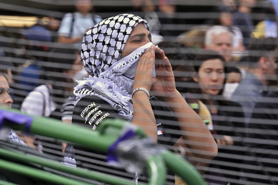 A man cheers after fellow demonstrators breeched barricades that had been erected around a pro-Palestinian encampment at MIT, Monday, May 6, 2024, in Cambridge, Mass. Protesters crossed the barricades to join other pro-Palestinian demonstrators who'd been given a deadline to leave the encampment. (AP Photo/Josh Reynolds)