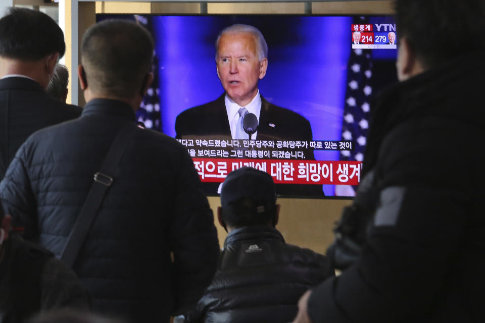 FILE - In this Nov. 8, 2020, file photo people watch a TV screen showing the live-broadcast of President-elect Joe Biden speaking, at the Seoul Railway Station in Seoul, South Korea. (AP Photo/Ahn Young-joon, File)