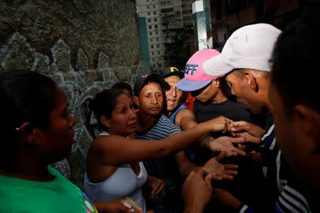 People argue while they queue on the street as they try to buy food outside a supermarket in Caracas, Venezuela March 17, 2017. REUTERS/Carlos Garcia Rawlins