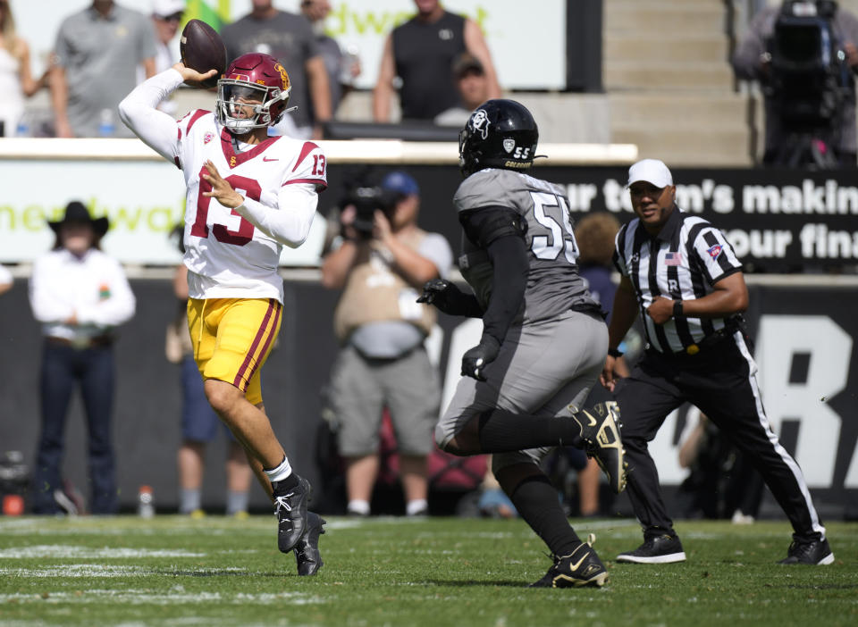 Southern California quarterback Caleb Williams, left, throws a pass under pressure from Colorado defensive lineman Leonard Payne Jr. in the second half of an NCAA college football game, Saturday, Sept. 30, 2023, in Boulder, Colo. (AP Photo/David Zalubowski)