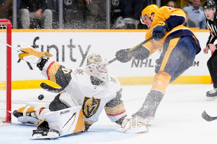 Vegas Golden Knights goaltender Jiri Patera (30) deflects a shot on goal by Nashville Predators defenseman Tyson Barrie, right, during the second period of an NHL hockey game Tuesday, March 26, 2024, in Nashville, Tenn. (AP Photo/George Walker IV)