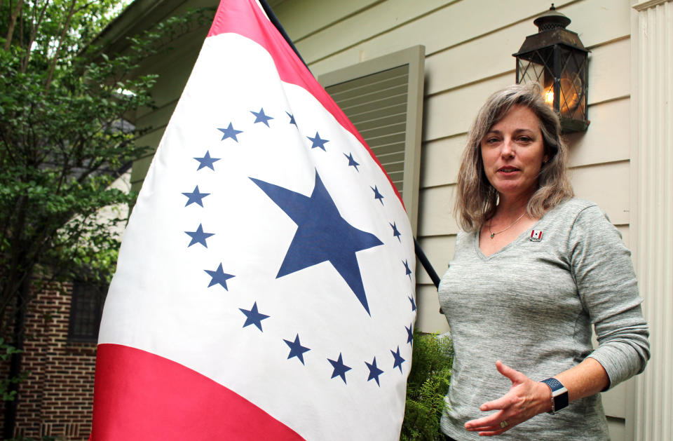 FILE- In this April 17, 2019 file photo, Laurin Stennis, an artist, speaks outside her home in Jackson, Miss., and explains how she thinks a flag she designed, which flies next to her, would be an appropriate symbol to replace the state flag that Mississippi has used since 1894. The current flag includes the Confederate battle emblem, and Stennis's design does not. (AP Photo/Emily Wagster Pettus, File)