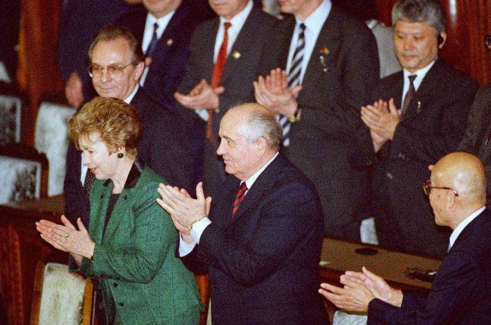 FILE - In this April 17, 1991 file photo, Soviet Union President Mikhail Gorbachev, center, accompanied by his wife, Raisa, applauds in responding to a standing ovation from Japanese lawmakers after his speech at the lower house of Parliament in Tokyo as House Speaker Yoshio Sakurauchi, right, and Soviet's Foreign Minister Alexander Bessmertnykh, top left, also applaud. Japan and the former Soviet Union restored diplomatic relations a decade after World War II, but a dispute over a cluster of islands kept them from signing a peace treaty. Russian President Vladimir Putin is in Japan on Thursday, Dec. 15, 2016 for a two-day talks with Japanese Prime Minister Shinzo Abe on the issue. In 1991, Gorbachev signed a communique recognizing the territorial dispute. (AP Photo/Itsuo Inouye, File)