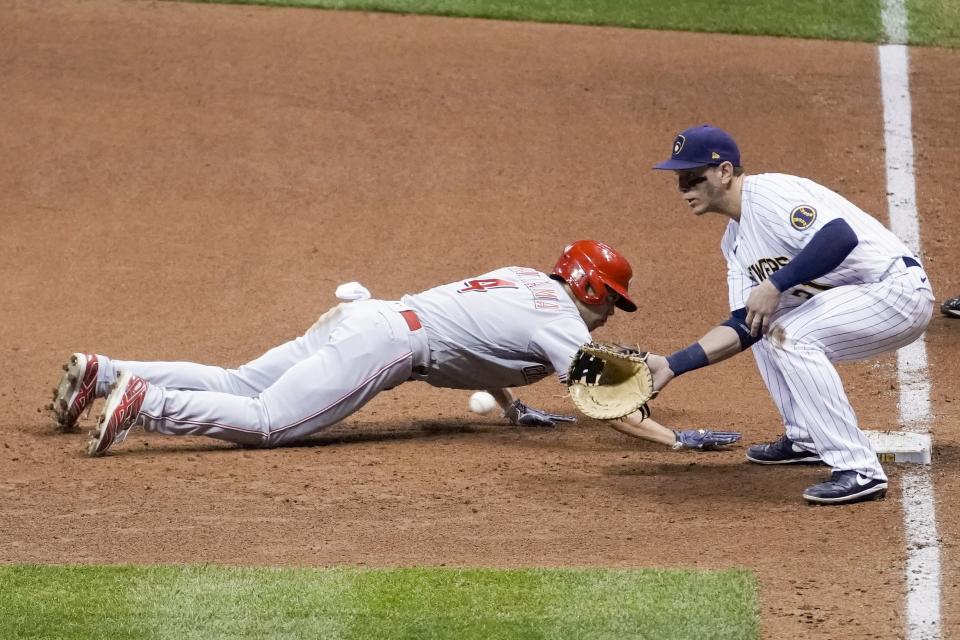 Cincinnati Reds' Shogo Akiyama slides safely back to first with Milwaukee Brewers' Logan Morrison covering on a pick off attempt during the ninth inning of a baseball game Saturday, Aug. 8, 2020, in Milwaukee. (AP Photo/Morry Gash)