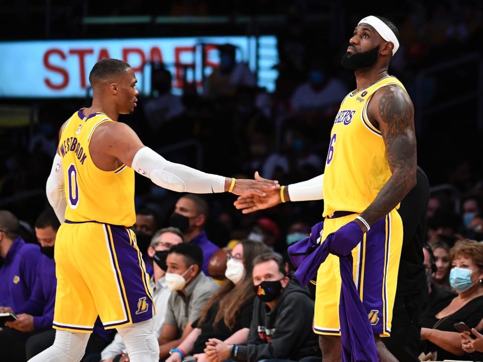 Russell Westbrook and LeBron James slap hands during a preseason game.