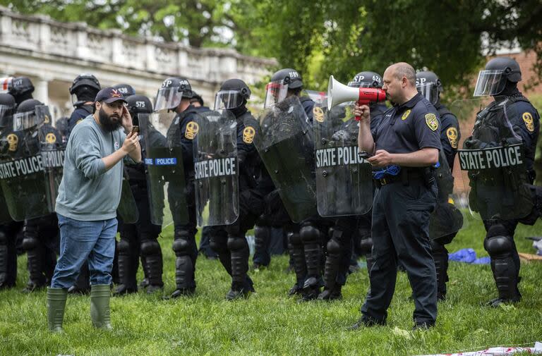La policía advierte a los manifestantes en la Universidad de Virginia, antes de desarmar sus carpas instaladas en Charlottesville. (Cal Cary/The Daily Progress via AP)