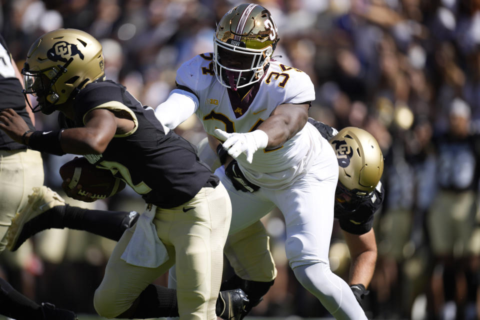 Minnesota defensive lineman Boye Mafe, right, reaches out to tackle Colorado quarterback Brendon Lewis in the first half of an NCAA college football game Saturday, Sept. 18, 2021, in Boulder, Colo. (AP Photo/David Zalubowski)