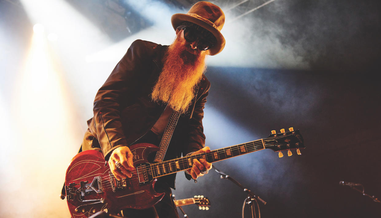  ZZ Top guitarist Billy Gibbons on stage playing an electric guitar. 