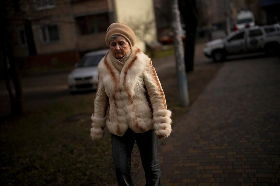 A woman walks by the scene where a helicopter crashed into civil infrastructure on Wednesday (AP)