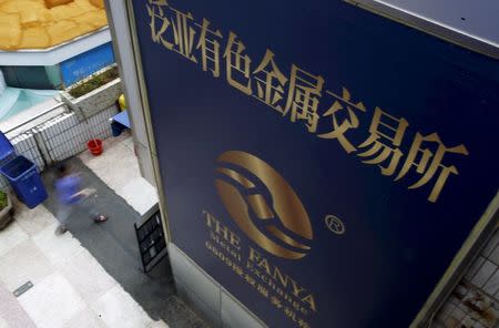 A woman walks past the company logo of the closed exchange centre of the Fanya Metal Exchange in downtown Kunming, Yunnan province, China, in this September 22, 2015 file photo. REUTERS/Stringer/Files