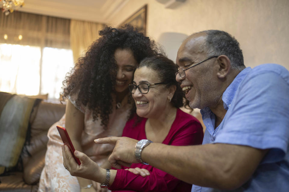 Yousra Sandabad and her parents, Mustafa and Afifa, make a video call with their relatives on the first day of Eid in lockdown due to the coronavirus pandemic, in Casablanca, Morocco, Sunday, May 24, 2020. Instead of mass prayers and large family gatherings filled with colorful clothes, gifts, and traditional foods, millions of Moroccan Muslims celebrated Eid Al-Fitr at home, subdued and isolated amid their country's newly extended coronavirus lockdown. (AP Photo/Mosa'ab Elshamy)