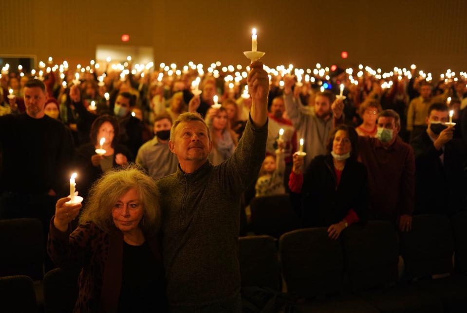 Terry Lamper of Rochester Hills and her husband Scott Lamper hold their candles up during a Christmas Eve church service at Kensington Church in Lake Orion on December 24, 2021.