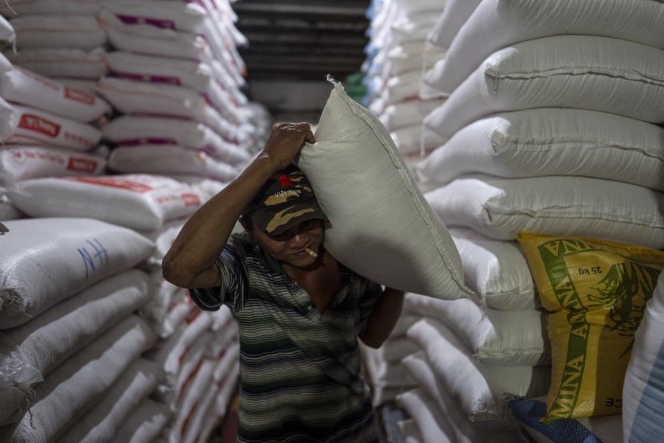 A worker carries a bag of rice at a warehouse in Ho Chi Minh City, Vietnam, Tuesday, Jan. 30, 2024. Vietnam is the world's third largest rice exporter, and the staple importance to Vietnamese culture is palpable in the Mekong Delta. (AP Photo/Jae C. Hong)