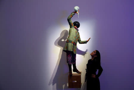 An employee poses as she views 'Bad School Boy' by Yinka Shonibare, which forms part of a forthcoming charity auction for the survivors of the London Grenfell Tower fire, at Sotheby's in London, Britain, October 12, 2017. REUTERS/Toby Melville