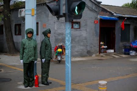 Paramilitary police officers wear rain protection suits as they keep watch in a hutong alley in the old part of Beijing as the capital prepares for the 19th National Congress of the Communist Party of China, October 14, 2017. REUTERS/Thomas Peter