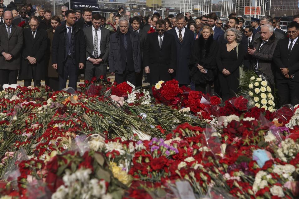 A group of ambassadors of foreign diplomatic missions attend a laying ceremony at a makeshift memorial in front of the Crocus City Hall on the western outskirts of Moscow, Russia, Saturday, March 30, 2024. (Sergei Ilnitsky/Pool Photo via AP)