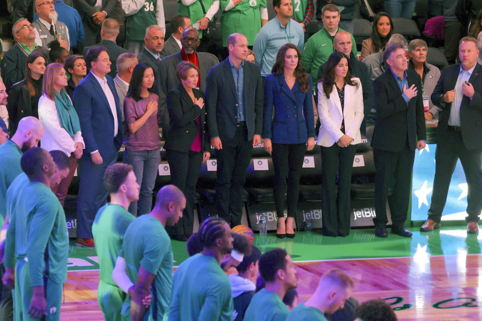 Celtics owner Steve Pagliuca, his wife Judy, Mayor of Boston Michelle Wu, Governor-elect Maura Healey, Britain's Prince William, center, Kate, Princess of Wales, Emilia Fazzalari, wife of Celtics owner Wyc Grousebeck and Wyc Grousebeck stand as they listen to the national anthem during an NBA basketball game between the Boston Celtics and the Miami Heat in Boston, Wednesday, Nov. 30, 2022. (Brian Snyder/Pool Photo via AP)