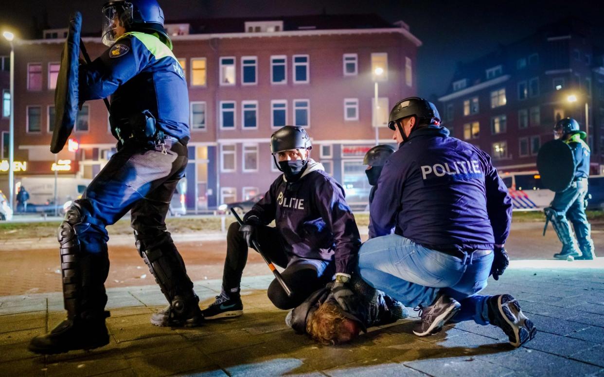 Dutch policemen arrest a man during clashes with a large group of young people on Beijerlandselaan in Rotterdam,