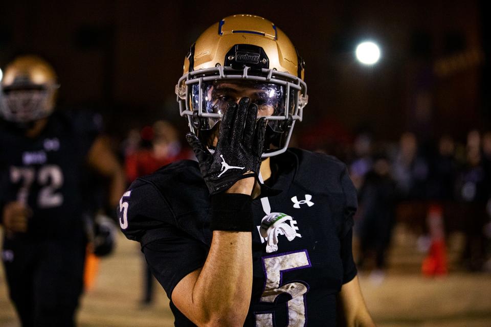 Male wide receiver Max Gainey (5) put his hand over his mouth while celebrating his first of two touchdowns as the Bulldogs defeated the Crimsons 14-3 on Friday night, Oct. 28, 2022