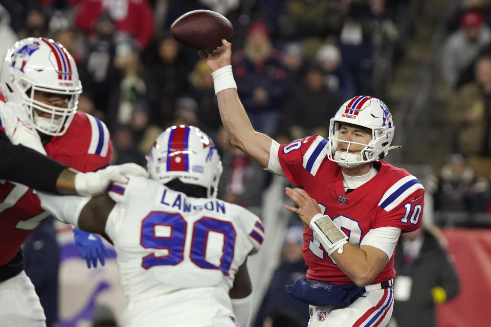 New England Patriots quarterback Mac Jones (10) throws a pass while pressured by Buffalo Bills defensive end Shaq Lawson (90) during the first half of an NFL football game, Thursday, Dec. 1, 2022, in Foxborough, Mass. (AP Photo/Steven Senne)