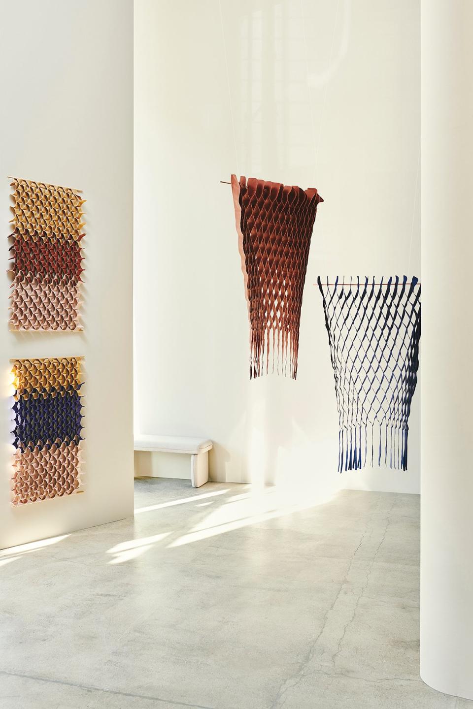 Honeycomb-like hanging textiles from the FLOW collection bring splashes of color and elegance to a modern living space.