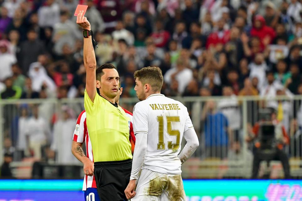 Spanish referee Jose Maria Sanchez Martinez (L) presents a red card to Real Madrid's Uruguayan midfielder Federico Valverde during the Spanish Super Cup final between Real Madrid and Atletico Madrid on January 12, 2020, at the King Abdullah Sports City in the Saudi Arabian port city of Jeddah. (Photo by Giuseppe CACACE / AFP) (Photo by GIUSEPPE CACACE/AFP via Getty Images)