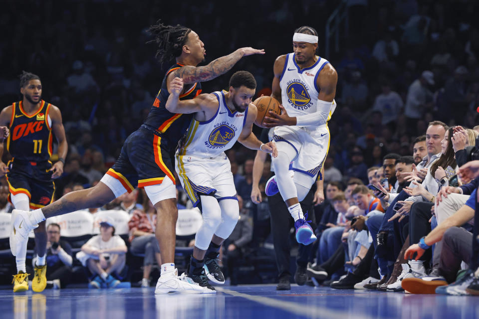 Golden State Warriors guard Gary Payton II, right, tries to save the ball from going out of bounds next to guard Stephen Curry, middle, and Oklahoma City Thunder forward Jaylin Williams during the first half of an NBA in-season tournament basketball game Friday, Nov. 3, 2023, in Oklahoma City. (AP Photo/Nate Billings)