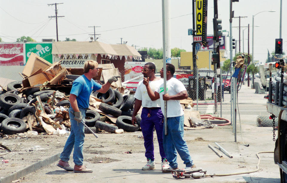 Armed with metal pipes, a construction worker (in blue) and demonstrators threaten one another during a protest on the northwest corner of the intersection of Florence and Normandie on Aug. 4, 1992. The demonstration was about the lack of Black employees on the job site.<span class="copyright">Bob Riha, Jr.—Getty Images</span>